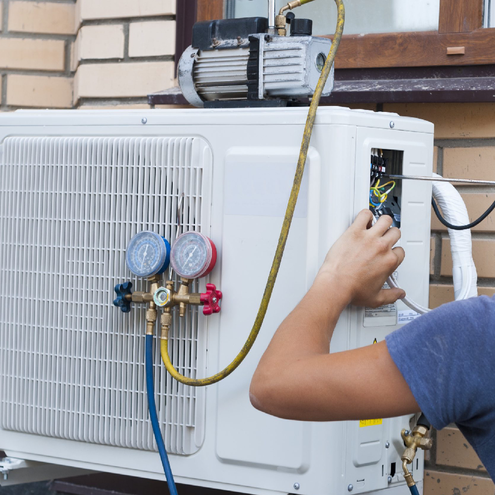 Technician repairing outdoor AC unit beside Georgetown home during hot afternoon service call