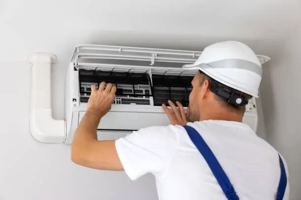 HVAC technician using diagnostic tools to trace source of residential AC malfunction