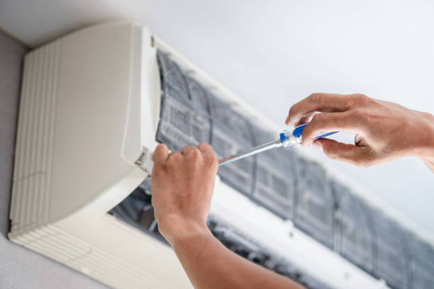 Experienced HVAC technician testing AC performance with gauges and airflow tools