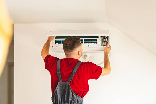 HVAC technician diagnosing weak airflow at two-story Leander home during hot afternoon
