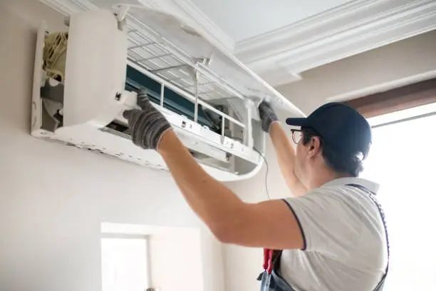 Technician diagnosing failed AC capacitor during afternoon cooling outage at Williamson County home